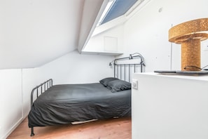 A small, modern bedroom with a skylight, a bed, a desk, and a lamp. - Rockefeller - The little New York loft (Dunkerque)