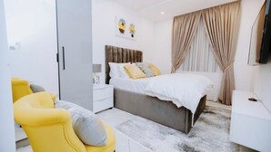 Une chambre à coucher moderne avec un lit, une table de chevet, une armoire et un fauteuil jaune.