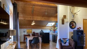 A cozy interior with wooden floors, a dining area, a kitchen, and a living space with a fireplace. - Wifi, 3rd floor, view ski slopes, balcony, parking, tv, ski locker, 70m², Les Gets (Les Gets)