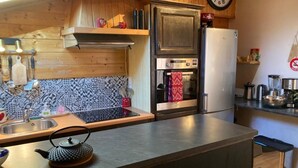 A kitchen with a stainless steel refrigerator, oven, and microwave. There is a sink with a faucet, and a kettle on the counter. - Wifi, 3rd floor, view ski slopes, balcony, parking, tv, ski locker, 70m², Les Gets (Les Gets)