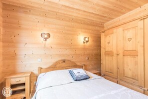 A wooden room with a bed, a nightstand, and a wardrobe. - 100m from resort center, 1st floor, parking, tv, ski locker, 63m², Les Gets (Les Gets)