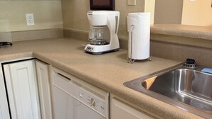 A kitchen with a coffee maker, paper towel holder, dishwasher, and a stainless steel sink. - Charming 2-bedroom apartment with AC in Holly Lake Ranch (Holly Lake Ranch)