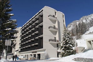Ein mehrstöckiges Hotel mit modernem Design, das einen zentralen Innenhof und Balkone auf jeder Etage bietet.