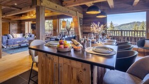 Un intérieur en bois comprenant un coin repas, un canapé et une vue sur l’extérieur.