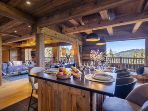 Ein Holzinterieur mit Essbereich, einer Couch und Blick ins Freie.