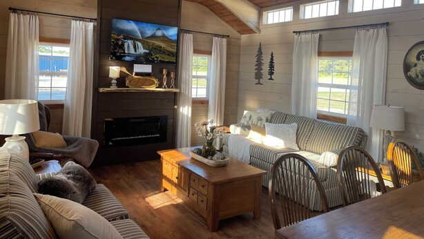 A cozy living room with a fireplace, wooden furniture, and a television.