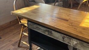 A dining area with a wooden table, chairs, a sofa, and a lamp.