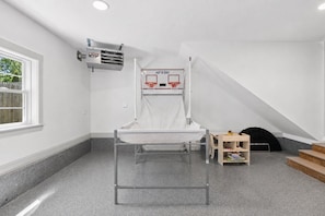 A room with a bunk bed, a small table, a window, and a staircase.