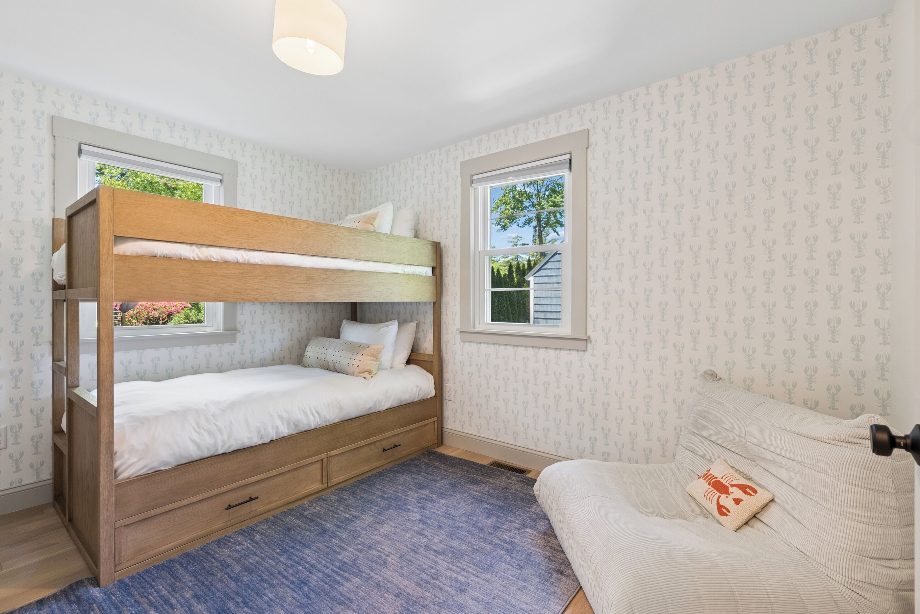 Une chambre avec un lit superposé, une fenêtre, un bureau et une chaise.