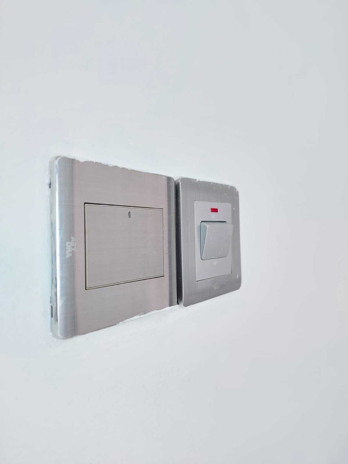 A wall-mounted light switch and a thermostat.