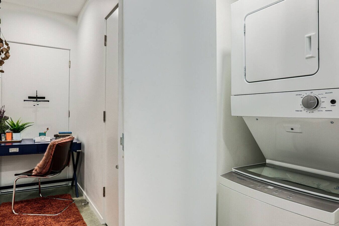 Une buanderie équipée d’un lave-linge, d’un sèche-linge et d’un bureau avec une chaise.