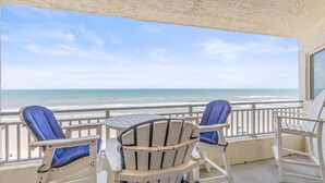 A balcony with two Adirondack chairs facing a beach view. - Seascape Towers 624 (New Smyrna Beach)