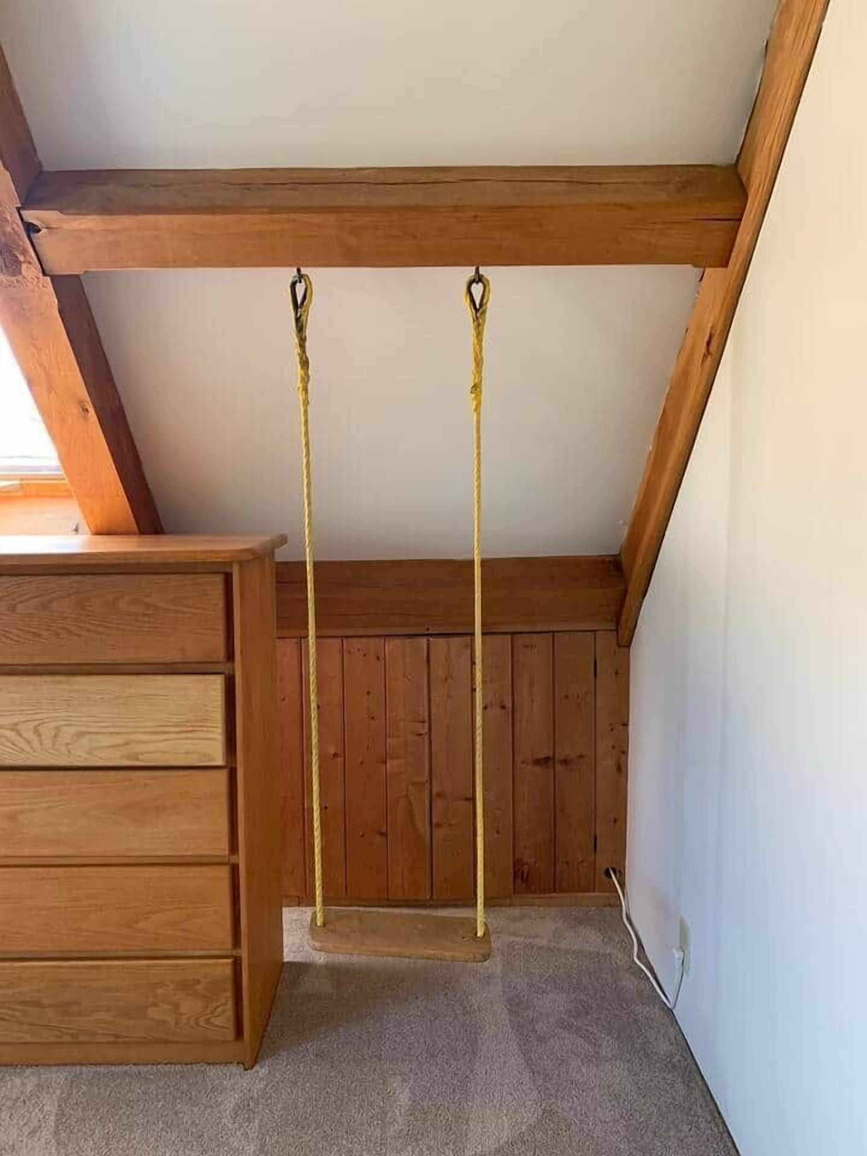 Ein Zimmer mit Holzbalkendecke, einem Holzschrank und Teppichboden.