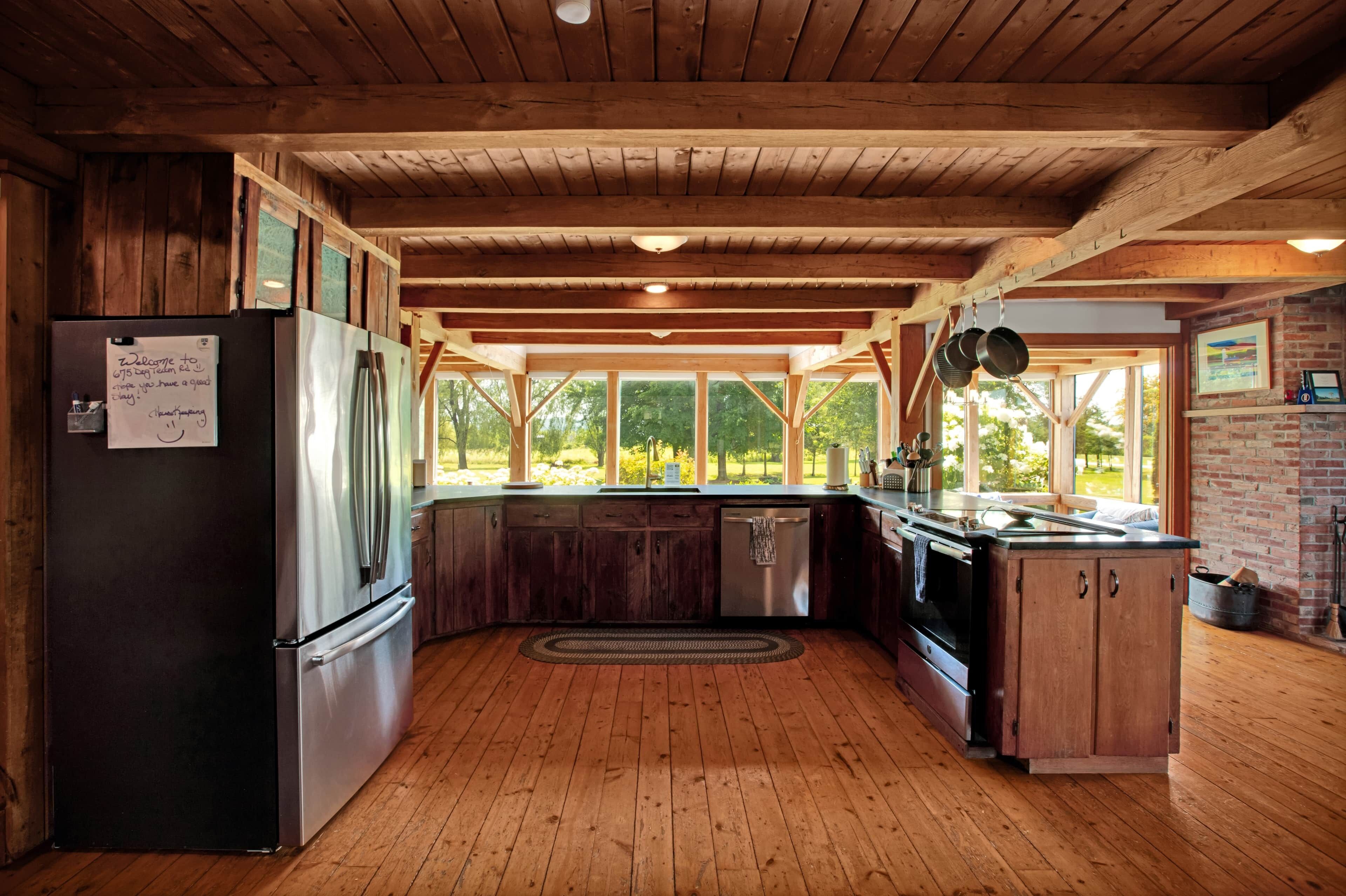 Une cuisine avec des poutres en bois, un réfrigérateur, une cuisinière et un évier.