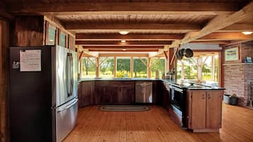 Une cuisine avec des poutres en bois, un réfrigérateur, une cuisinière et un évier.