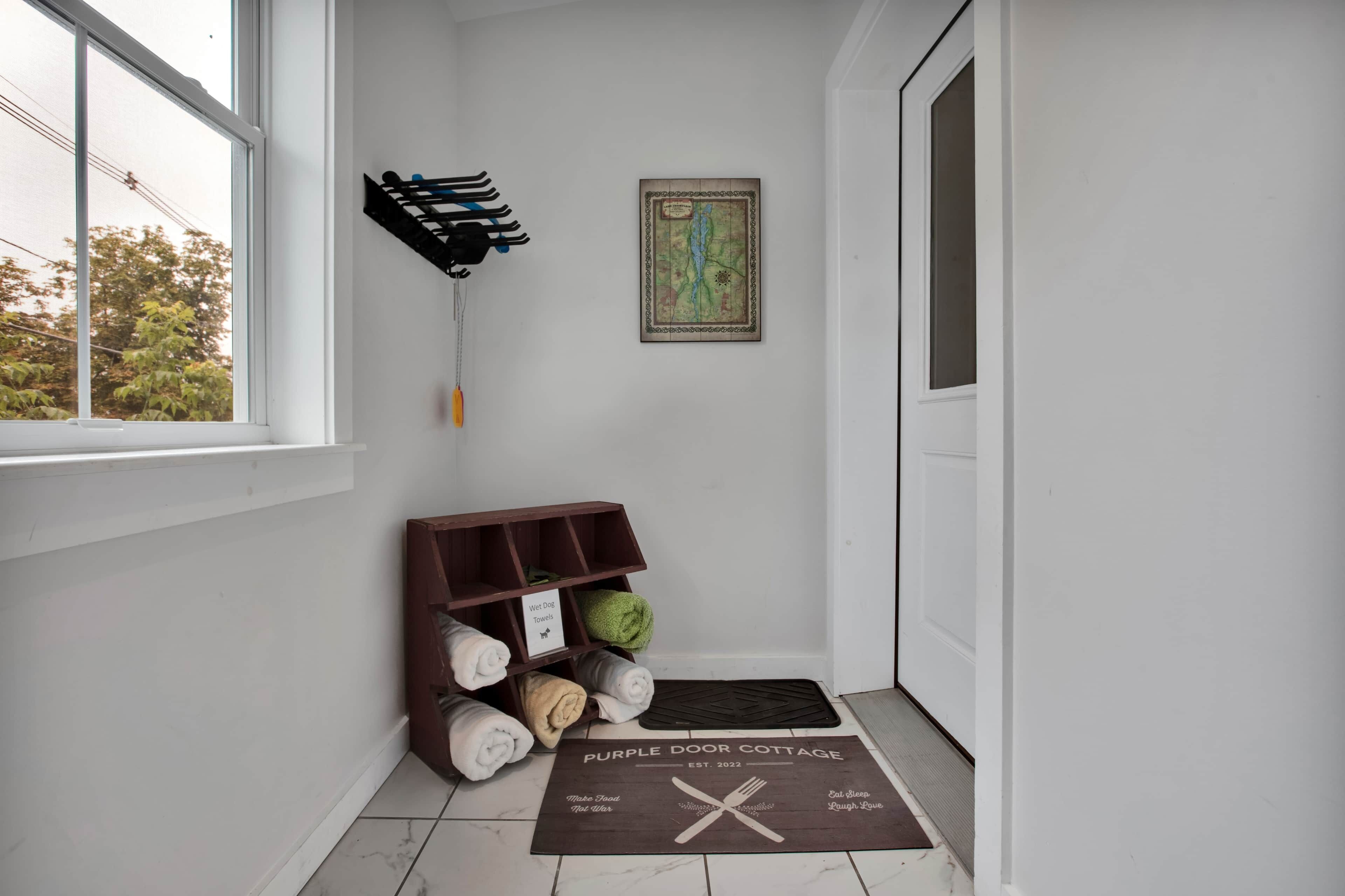 A hallway with a dog bed, a wall-mounted rack, and a welcome mat.