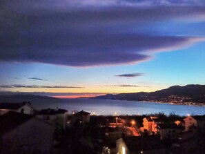 A coastal town at dusk with houses and a body of water. - Villa Vrata Jadrana 1 (Rijeka)