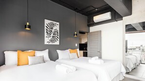 Hotellihuone, jossa on kaksi sänkyä, suuri ikkuna ja näkymä kaupunkiin.