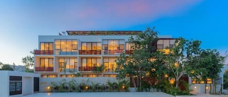 A multi-story hotel with a modern design, featuring balconies and large windows.