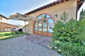 A patio with a table and chairs, a covered umbrella, and a stone wall. - SwimmingPool ONLY FOR YOU in Villa with AirCon for 26/30 pax in 13 bedrooms (Toscana)