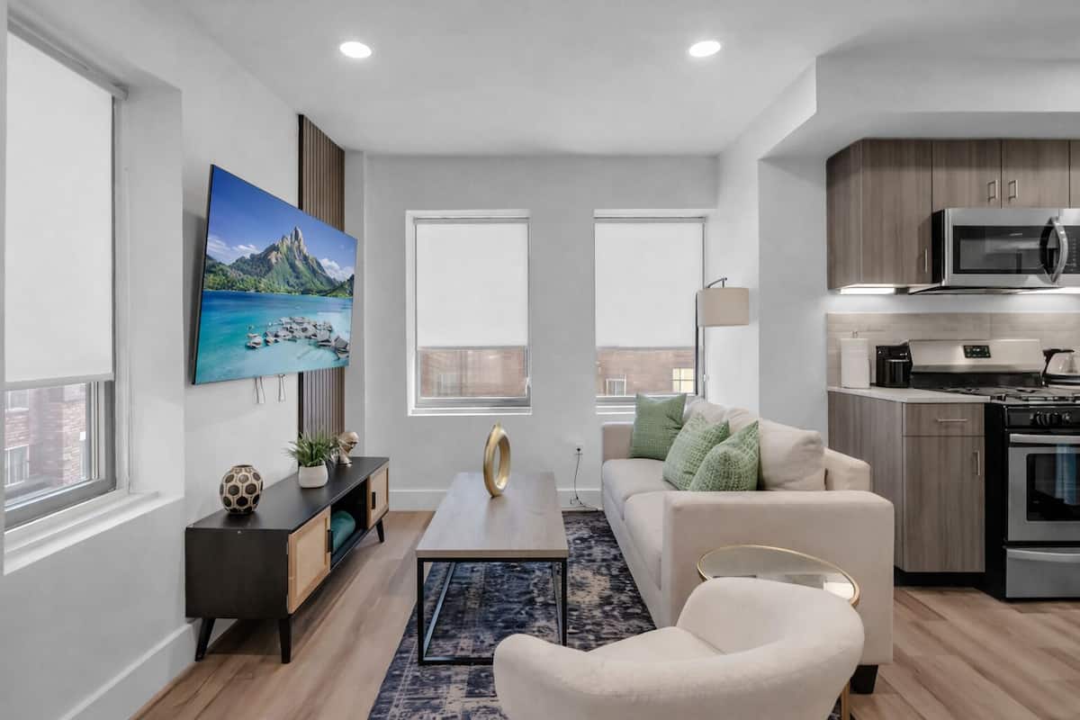 A modern apartment with a living room, kitchen, and large windows.