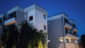 Un edificio moderno de varios pisos con balcones y cielo despejado.