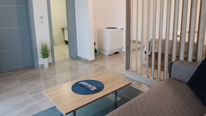 A modern living room with a sofa, a coffee table, a clock, and a sliding door. - Dalmatia Apartments-Studio Apartment with Balcony 3a (Drage)