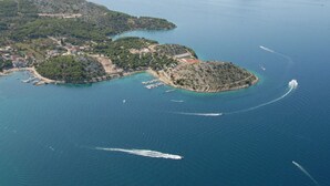 An aerial view of a coastal area with multiple islands, clear blue waters, and a few boats. - Dalmatia Apartments-Studio Apartment with Balcony 5a (Drage)