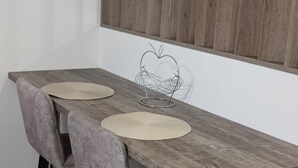 A dining table with two chairs, a metal wire basket, and two placemats. - Dalmatia Apartments- Studio Apartment with Balcony and Sea View 4a (Drage)