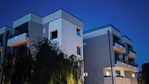 Un immeuble moderne à plusieurs étages, doté de balcons, avec un ciel dégagé.