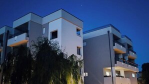 Een modern meerlaags gebouw met balkons en een heldere lucht.