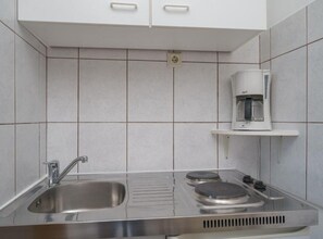 Placa de cocina, cafetera o tetera y utensilios de cocina