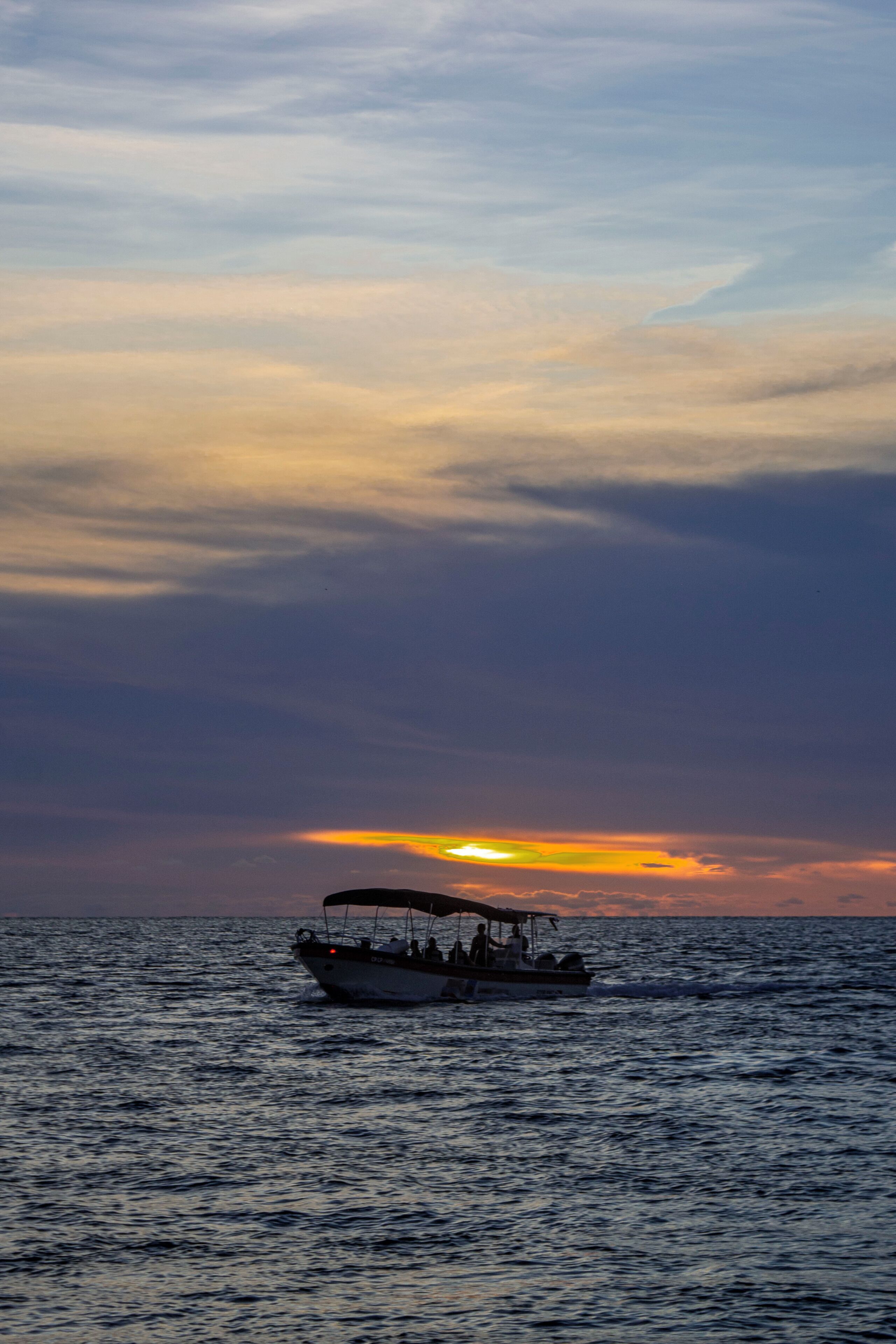 A boat on calm water during sunset.