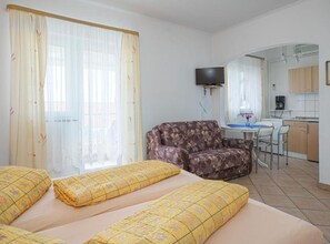 A room with a bed, a sofa, a TV, a kitchen area, and a dining table. - Apartments Milka Vodice - Studio Apartment with Balcony (Vodice)