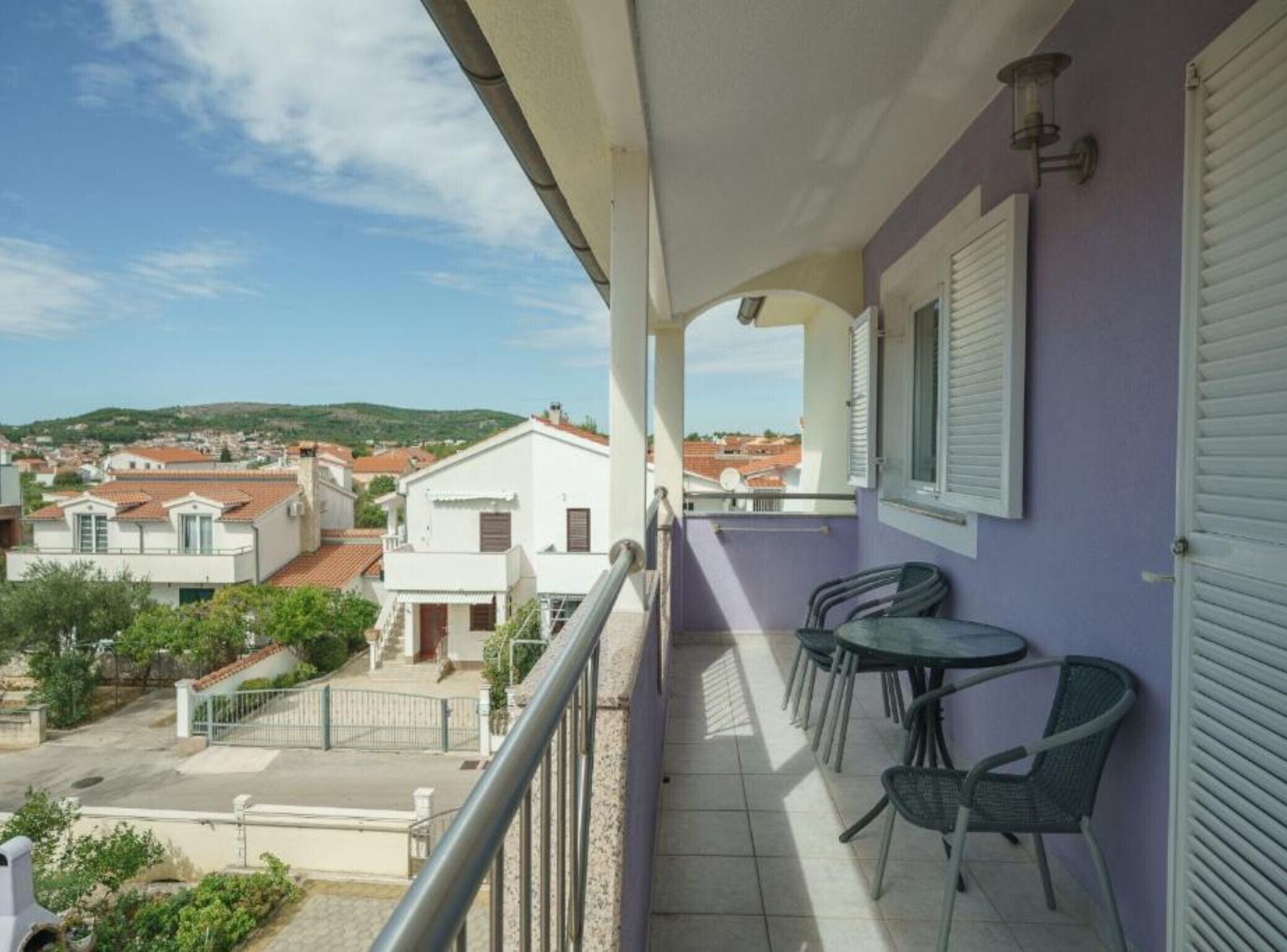 Un balcon donnant sur la ville, une table avec des chaises et une balustrade.