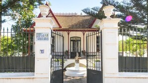 Une entrée fermée par un portail, une fontaine, une enseigne indiquant « Las Araucarias », et un bâtiment doté d’un toit en tuiles.