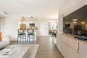 Ein modernes Apartment mit Küche, Essbereich und Wohnzimmer.