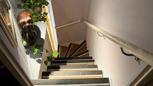 A staircase with wooden steps and a metal handrail, a wall-mounted plant, and a decorative object. - Cozy flat in the heart of the Lanes, with a game room and space up to 4 people (Brighton and Hove)