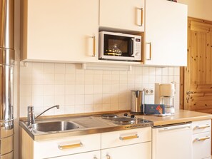 A kitchen with a stainless steel sink, a microwave, a coffee maker, and a Siemens brand oven. - # 34OG für bis zu 4 Personen by Interhome (Sankt Georgen am Kreischberg)
