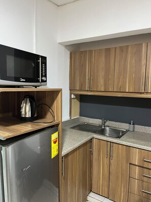 Suite estudio | Cocina privada | Frigorífico pequeño, microondas, placa de cocina y utensilios de cocina