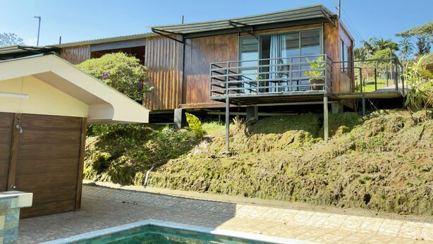 A modern house with a pool, wooden deck, and a view of the surrounding landscape. - Paulos View Lodge (Venecia)