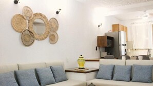 A living room with two sofas, a coffee table, and a wall-mounted mirror. - Casa Coral (Manzanillo)