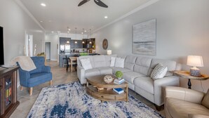 Una sala moderna con sofá, mesa de centro y mueble para televisor.
