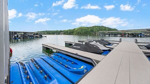 Un puerto deportivo con barcos amarrados, un muelle de madera y un puente al fondo.