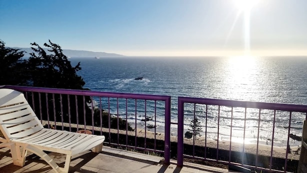 A balcony with a view of the ocean, a white chair, and a purple railing. - Apartment close to the beach, restaurant and beautiful sunsets. (Viña del Mar)
