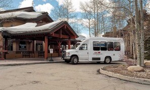 Ein weißer Bus ist vor einem Gebäude geparkt, an dem ein Schild mit der Aufschrift 'Chilterns Inn' angebracht ist.