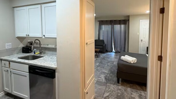 A compact hotel room with a kitchenette, a bed, and a bathroom. - Relax and Refresh at this Studio Apt. in South ATX (Austin)