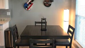 Ein Essbereich mit Tisch, Stühlen und zwei an der Wand befestigten Gitarren.