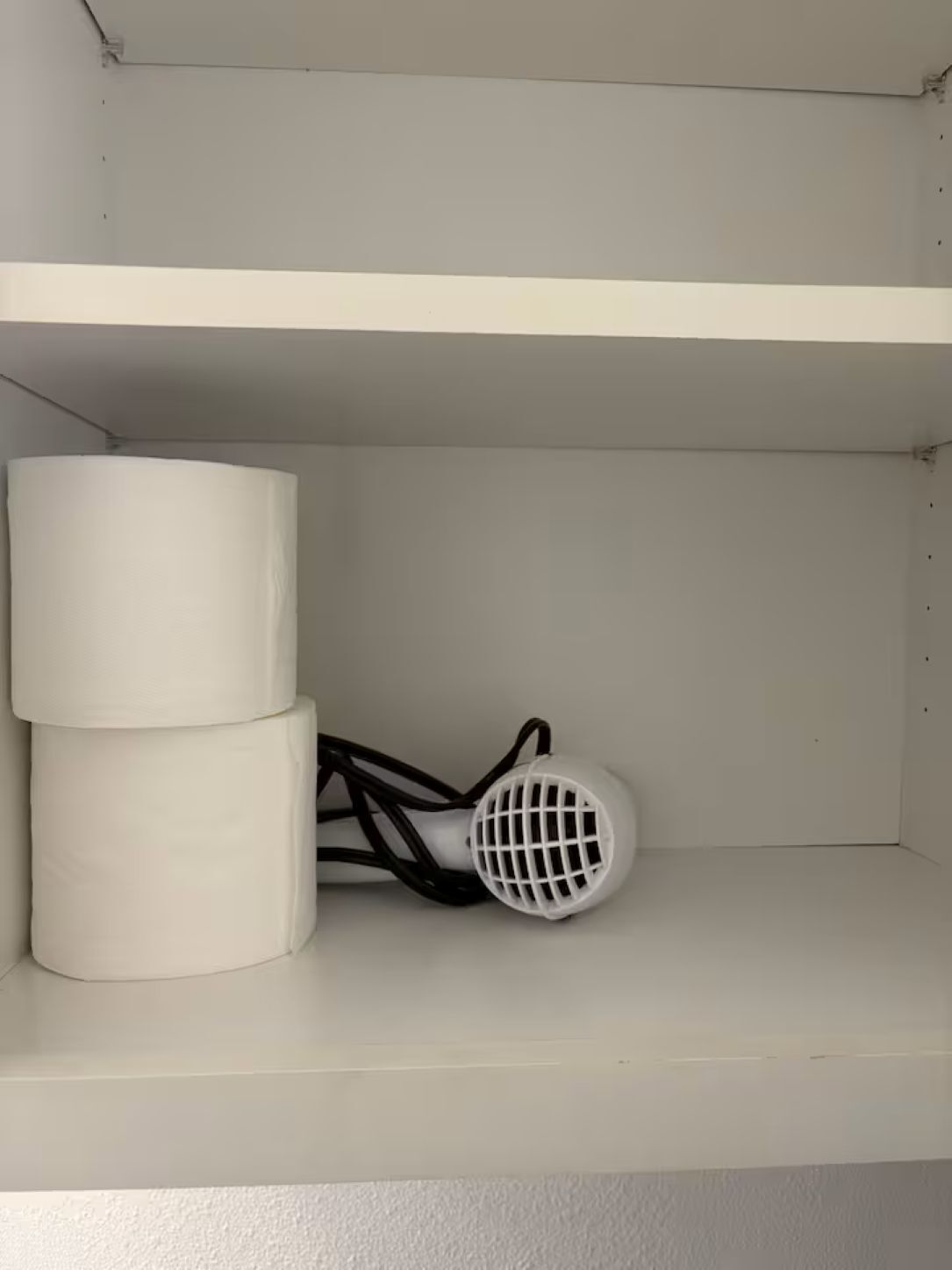 Een witte plank met twee cilindrische objecten en een wit apparaat met een rasterpatroon.