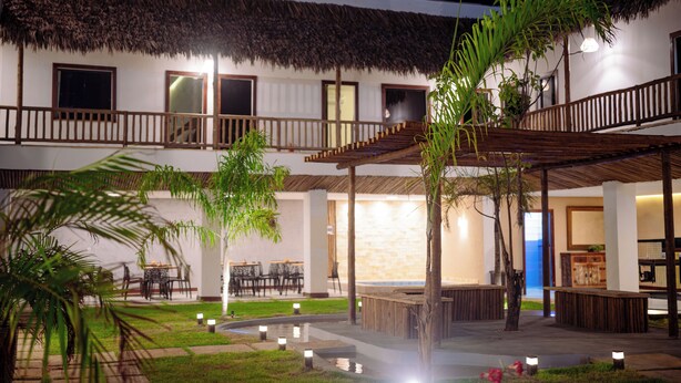 Ein Hotel mit Strohdach, Außenbereich und Poolanlage.